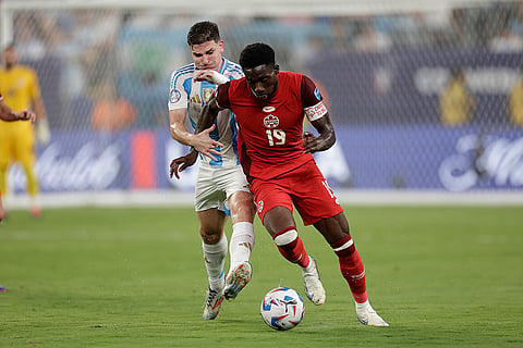 Julian Alvarez and Alphonso Davies vie for the ball